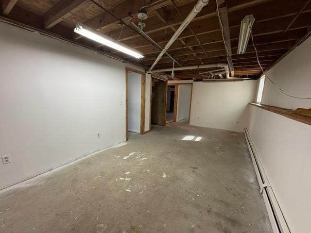 unfinished basement featuring baseboard heating