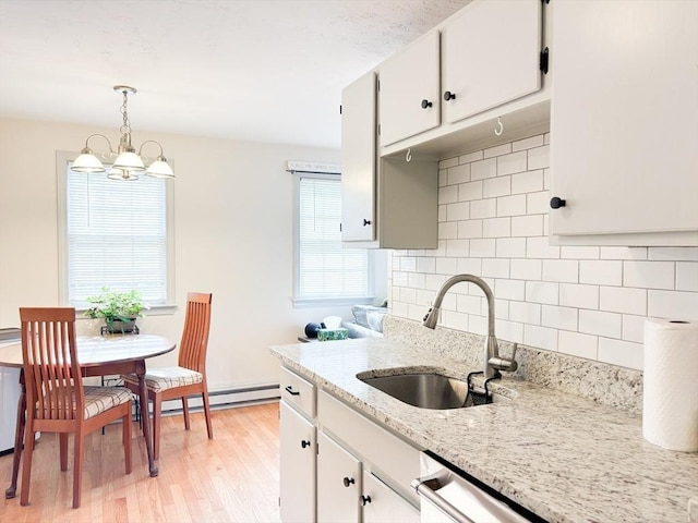 110 W Main St Unit 30, Barnstable, MA 02601 - kitchen featuring a sink, a chandelier, light wood-style floors, tasteful backsplash, and decorative light fixtures