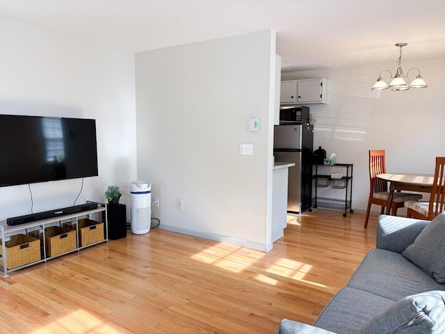 110 W Main St Unit 30, Barnstable, MA 02601 - living area with a chandelier, light wood-type flooring, and baseboards