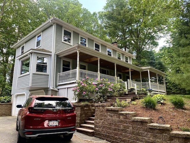 15 Shufelt Rd, Walpole, MA 02071 - view of front facade featuring an attached garage, covered porch, a chimney, stairs, and driveway