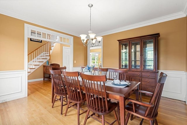 160 Wharton Row, Groton, MA 01450 - dining room featuring stairs, ornamental molding, a chandelier, light wood-style floors, and wainscoting