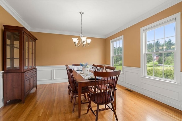 160 Wharton Row, Groton, MA 01450 - dining area featuring light wood-style floors, ornamental molding, a chandelier, a wainscoted wall, and a decorative wall