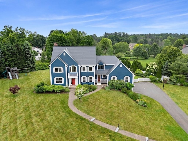 160 Wharton Row, Groton, MA 01450 - view of front of house featuring driveway, a front yard, a chimney, and view of wooded area