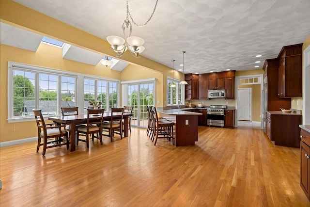 160 Wharton Row, Groton, MA 01450 - kitchen with appliances with stainless steel finishes, a kitchen breakfast bar, light wood finished floors, healthy amount of natural light, and recessed lighting
