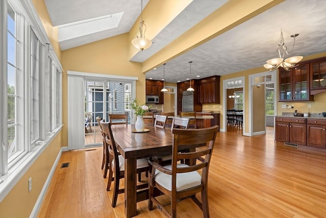 160 Wharton Row, Groton, MA 01450 - dining area with light wood-style flooring, a skylight, lofted ceiling, and a chandelier