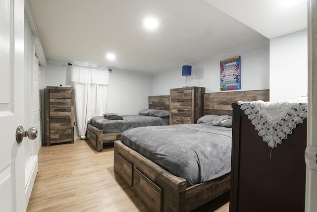 bedroom featuring light wood-style floors and crown molding