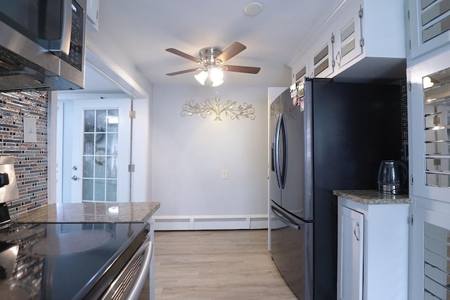 kitchen with stone countertops, ceiling fan, light wood-style floors, appliances with stainless steel finishes, and white cabinetry