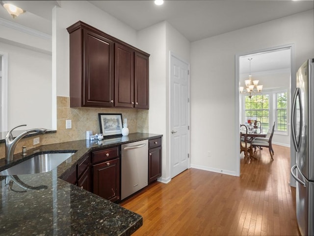 72 Sherwood Dr Unit 72, Methuen, MA 01844 - kitchen featuring stainless steel appliances, a chandelier, light wood-type flooring, crown molding, and dark stone countertops