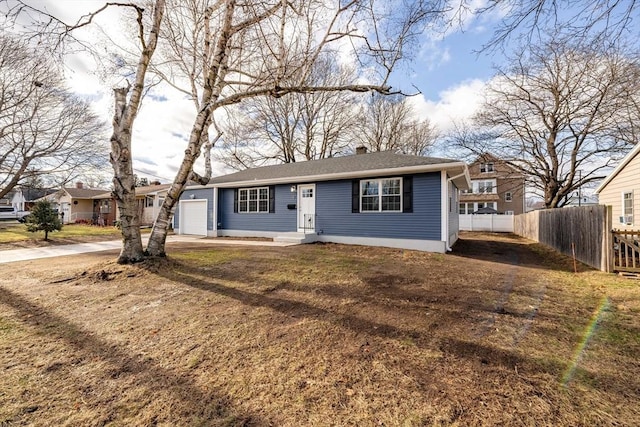 ranch-style home featuring a garage and a front lawn