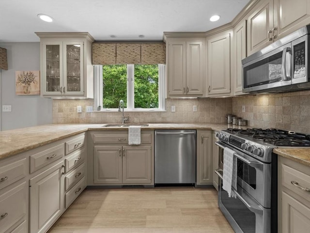 1 Benjamin Dr, Westborough, MA 01581 - kitchen with stainless steel appliances, a sink, backsplash, glass insert cabinets, and recessed lighting