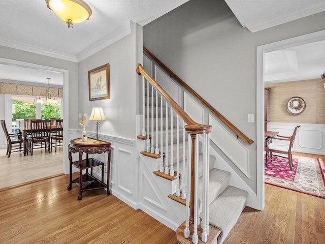 1 Benjamin Dr, Westborough, MA 01581 - stairway with wood finished floors, a decorative wall, ornamental molding, wainscoting, and a chandelier