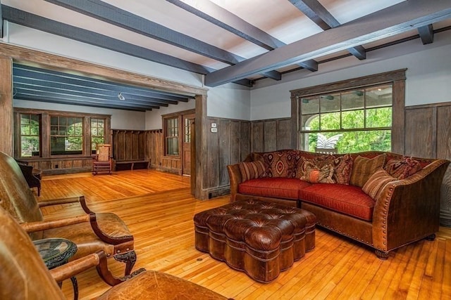 living room featuring wooden walls, beamed ceiling, and hardwood / wood-style flooring