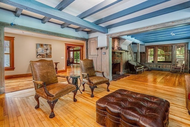 interior space with a fireplace, beamed ceiling, and hardwood / wood-style flooring