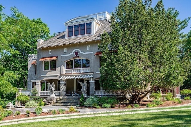 view of front of property with a porch and a front lawn