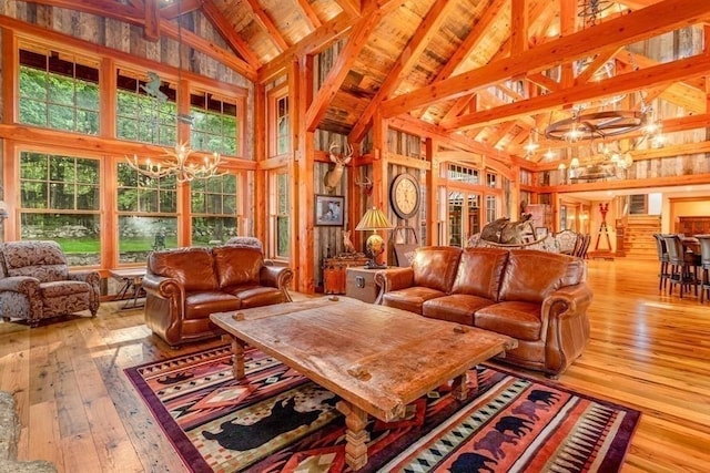 living room featuring wood ceiling, beam ceiling, high vaulted ceiling, a notable chandelier, and light hardwood / wood-style floors