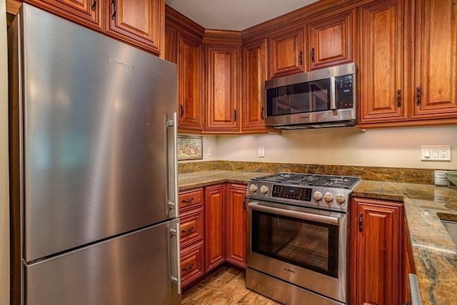 kitchen with light stone countertops and appliances with stainless steel finishes