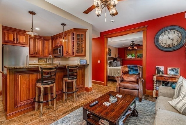 living room featuring hardwood / wood-style flooring, ceiling fan, and sink