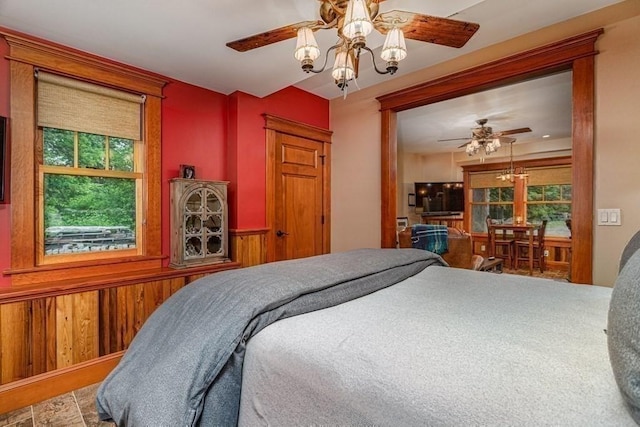 bedroom featuring wood walls and an inviting chandelier