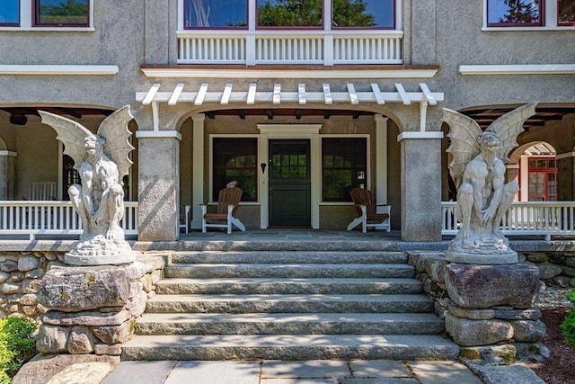 property entrance with a balcony and a porch