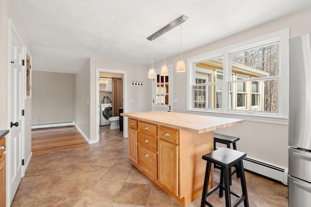 kitchen with a baseboard radiator, wooden counters, washer / dryer, and freestanding refrigerator