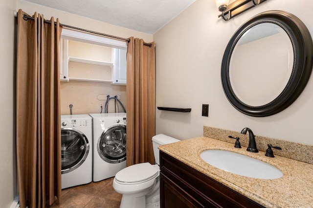 bathroom with baseboard heating, toilet, vanity, and separate washer and dryer