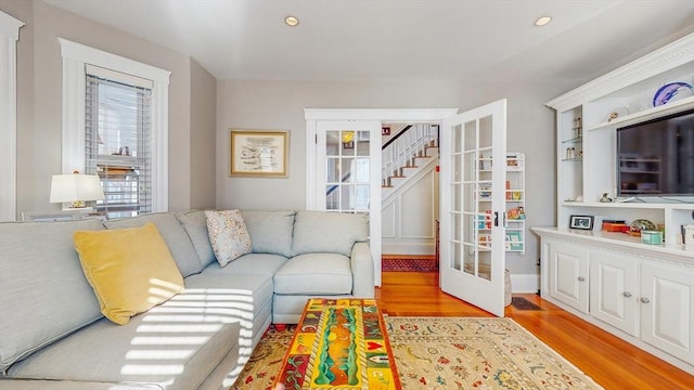 living room with french doors and light wood-type flooring