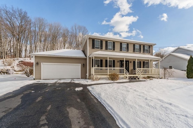 colonial inspired home with a garage, covered porch, and aphalt driveway