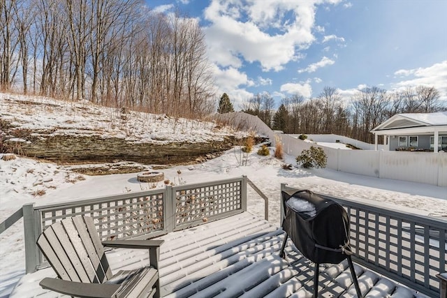 snow covered deck featuring a grill and fence