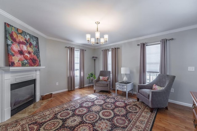 sitting room with light wood-type flooring, a chandelier, and crown molding