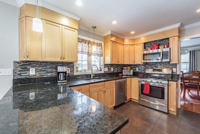 kitchen featuring hanging light fixtures, light brown cabinets, appliances with stainless steel finishes, and a sink