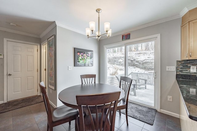 dining room featuring baseboards, dark tile patterned flooring, ornamental molding, and a notable chandelier