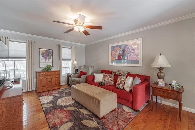 living room with ornamental molding, light wood-type flooring, baseboards, and a ceiling fan