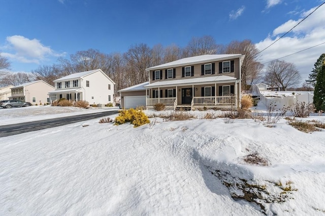 colonial inspired home featuring an attached garage and a porch