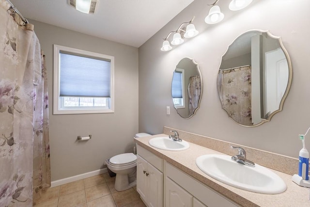 full bath featuring double vanity, a sink, toilet, and tile patterned floors