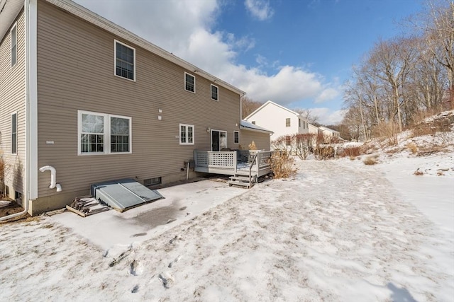 snow covered property with a wooden deck