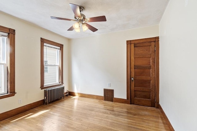 49-51 Fairmount Ave, Somerville, MA 02144 - empty room with radiator heating unit, light wood finished floors, ceiling fan, and baseboards