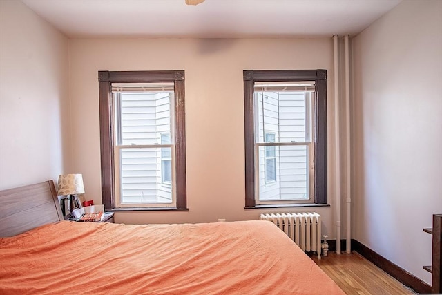 49-51 Fairmount Ave, Somerville, MA 02144 - bedroom with radiator heating unit, wood finished floors, multiple windows, and baseboards