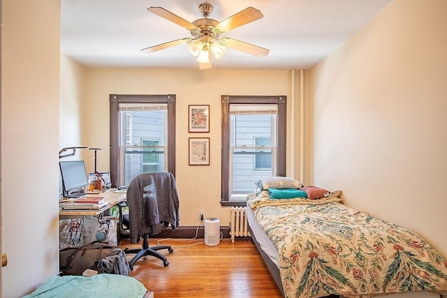 49-51 Fairmount Ave, Somerville, MA 02144 - bedroom featuring radiator, light wood-style floors, a desk, and a ceiling fan