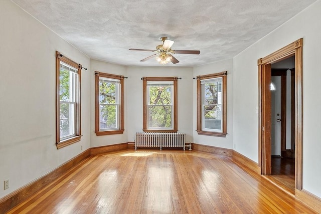 49-51 Fairmount Ave, Somerville, MA 02144 - unfurnished room with radiator, light wood finished floors, a ceiling fan, baseboards, and a textured ceiling