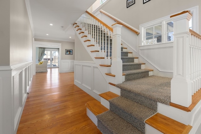 staircase featuring crown molding and wood-type flooring