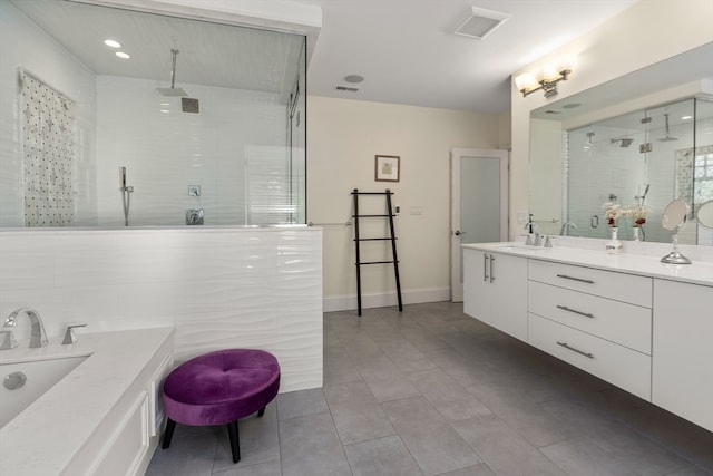 bathroom featuring vanity, tiled shower, and tile patterned flooring