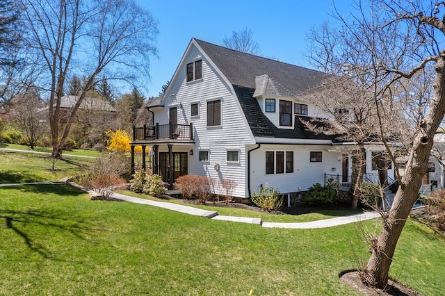 exterior space with a balcony and a front lawn