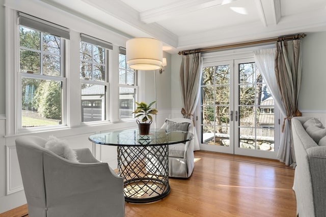 dining space with a wealth of natural light, light hardwood / wood-style flooring, and beam ceiling