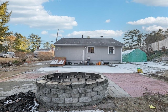 back of property with a patio area and an outdoor fire pit