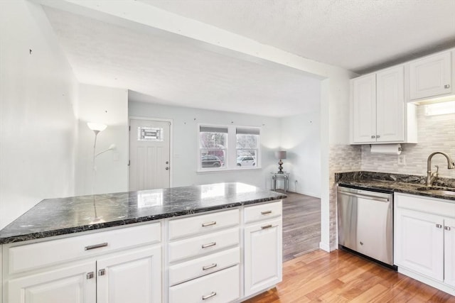 kitchen with white cabinets, dishwasher, dark stone countertops, sink, and light hardwood / wood-style flooring