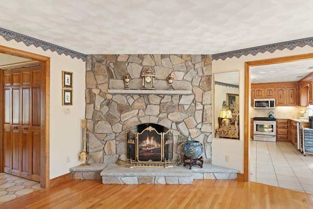 unfurnished living room featuring a textured ceiling, light wood-style flooring, and a fireplace