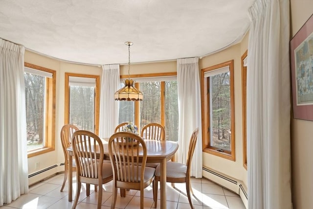 dining room featuring light tile patterned flooring, a wealth of natural light, and a baseboard radiator