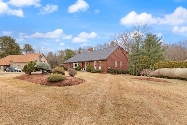 view of front facade with a chimney and a front yard