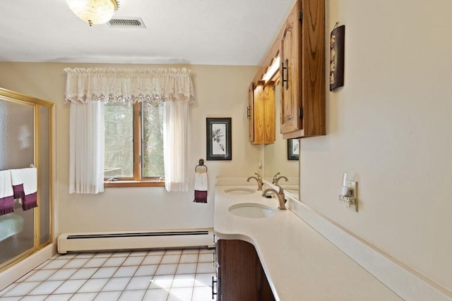 full bath featuring visible vents, a shower stall, double vanity, baseboard heating, and a sink