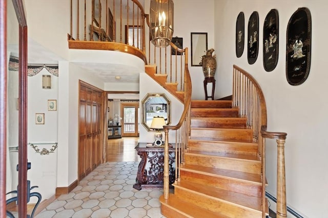 entryway with a notable chandelier, stairs, and a baseboard radiator